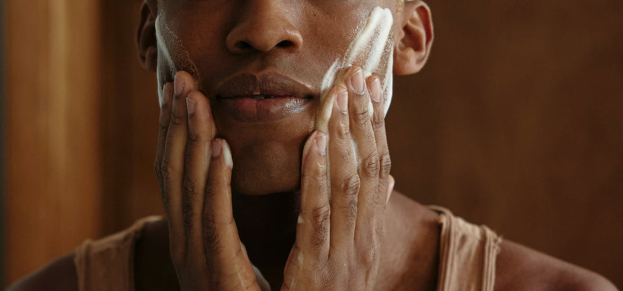 Mann trägt Peeling im Gesicht auf