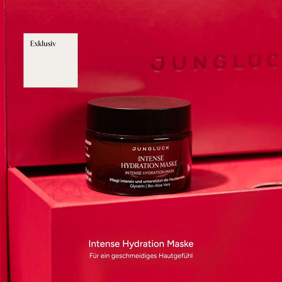 Die Intense Hydration Maske in einem Braunglasbehälter, platziert in einer rot glänzenden Box mit lesbarem Text.