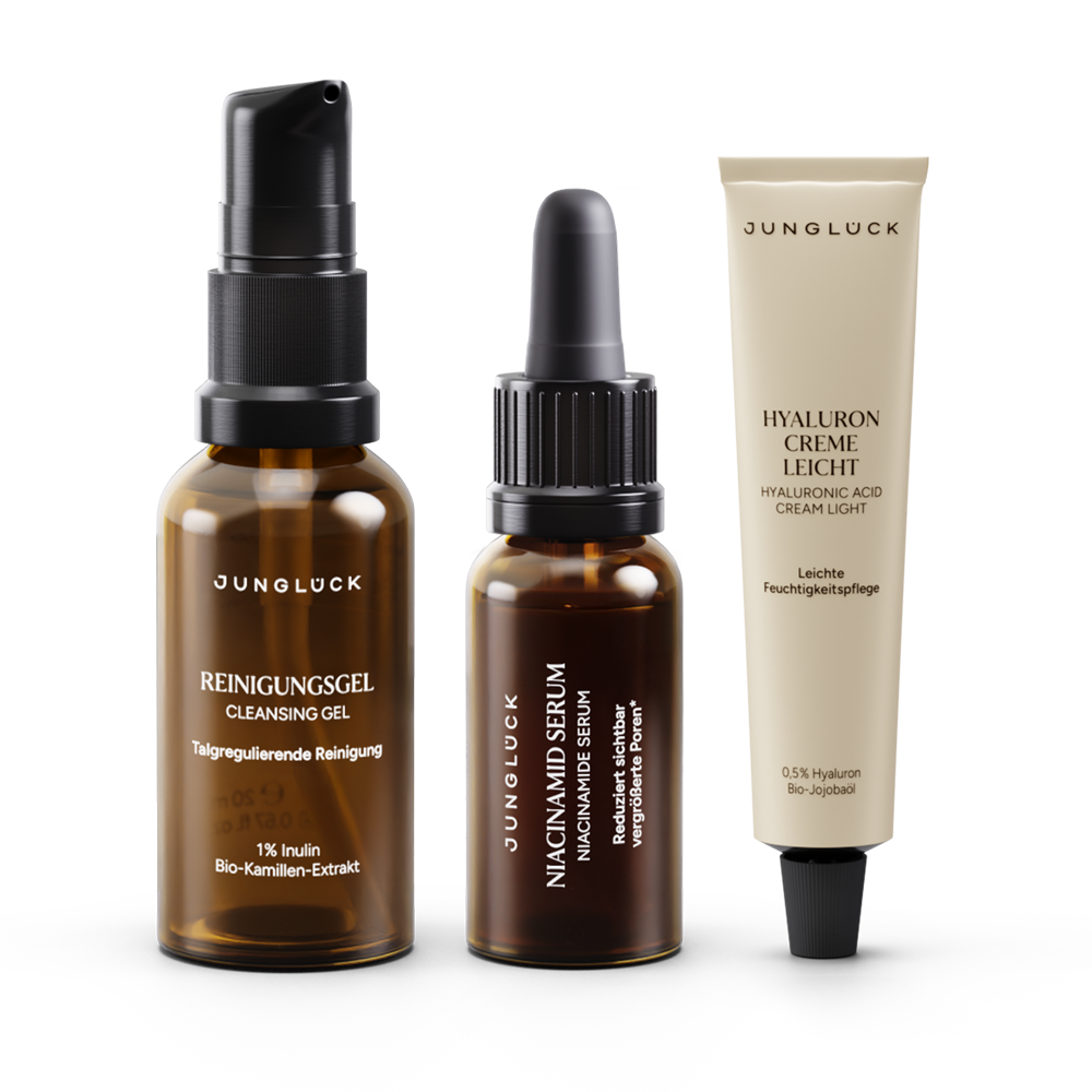 Drei JUNGLÜCK Produkte: ein Braunglas-Reinigungs-Gel, ein Niacinamid-Serum und eine leichte Hyaluron Creme in Tuben.